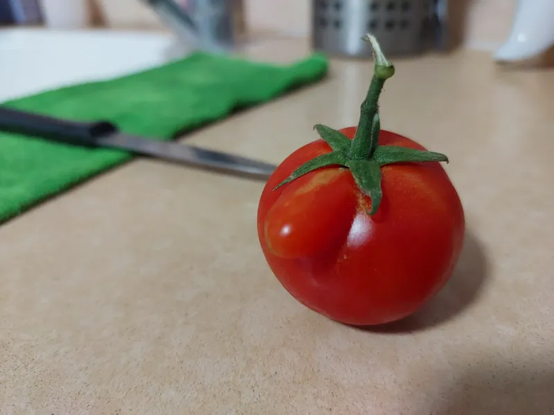 עגבנייה אדומה וסכין על משטח